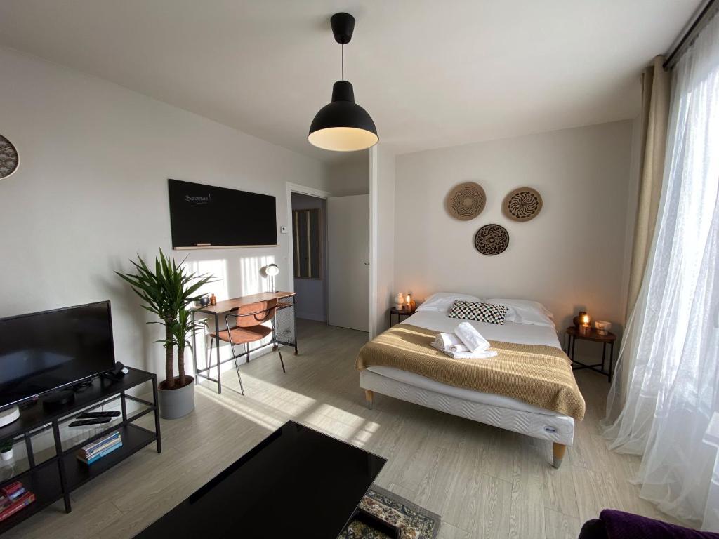une chambre avec un lit et une télévision à écran plat dans l'établissement Grand studio calme avec balcon & parking gratuit, à Tours