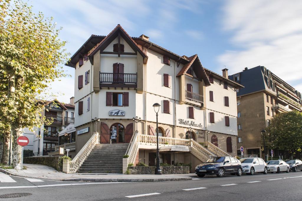 a white building with stairs on a city street at Hotel Alameda in Zarautz