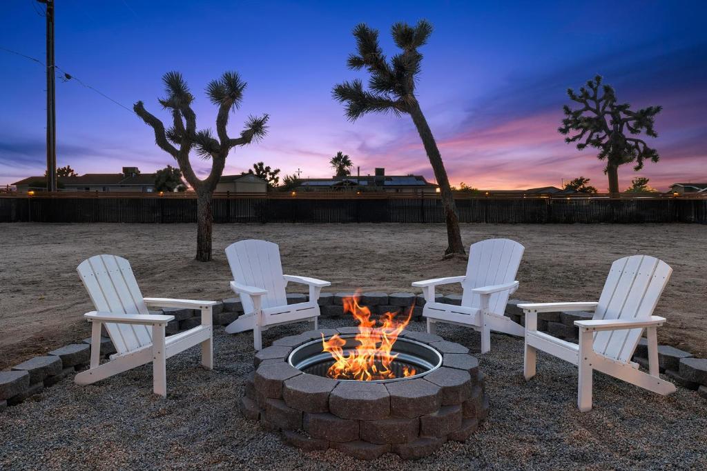 a group of chairs around a fire pit at sunset at Modern Desert Escape - Fire Pit, BBQ and Design! home in Yucca Valley