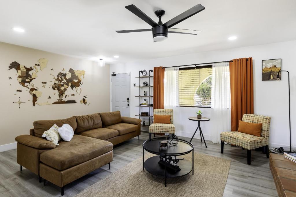 a living room with a couch and a ceiling fan at Sky Harbor House - Centrally Located withHot Tub home in Yucca Valley