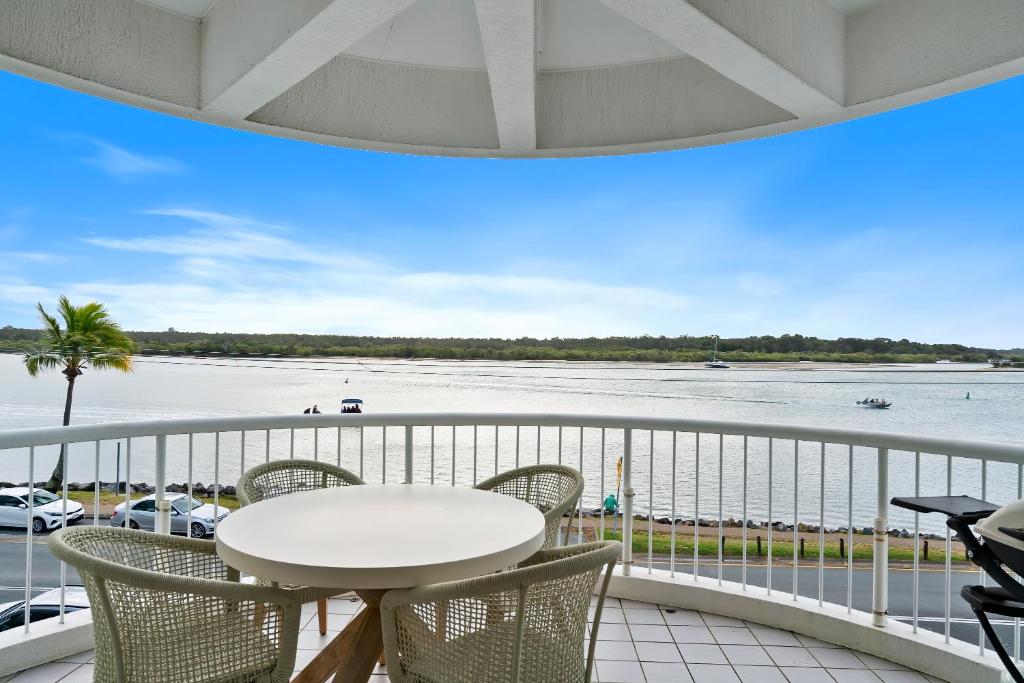 a balcony with a table and chairs and a view of the water at HOWARD ST Panoramic River and Ocean Views - Penthouse -Rooftop in Noosaville