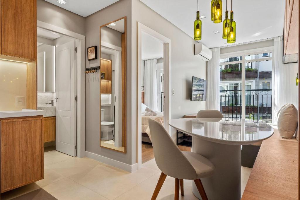 a kitchen and dining room with a table and chairs at Apartamento Viña del Aire 1 dorm by Achei Gramado in Gramado