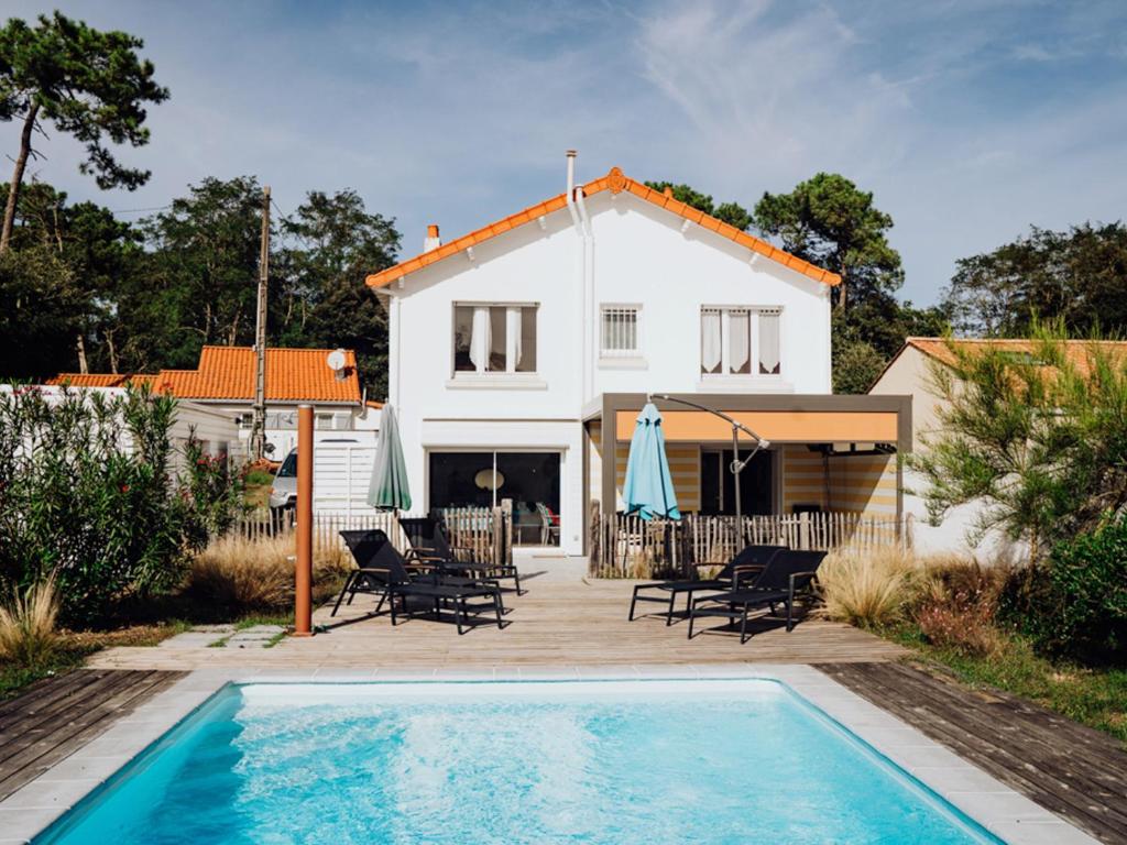 une maison avec une piscine devant une maison dans l'établissement Maison indépendante avec jardin, piscine privée chauffée et Wi-Fi, près de la mer à Jard-sur-Mer - FR-1-336-115, à Jard-sur-Mer