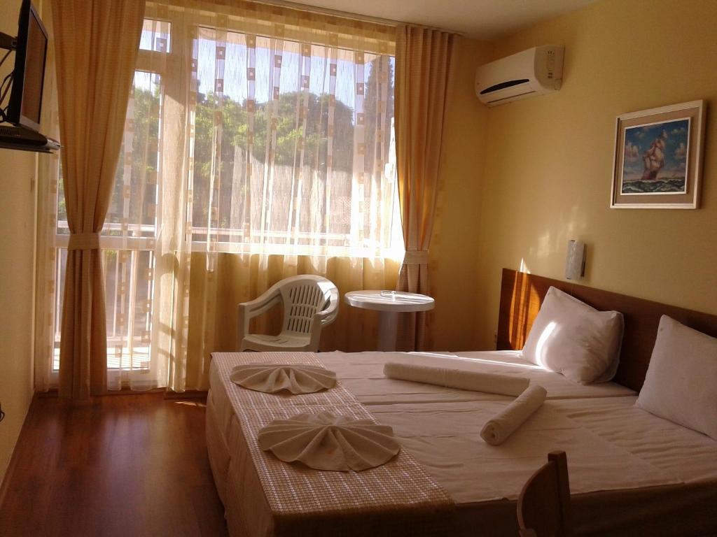 ソゾポルにあるStephanovy Guest Houseのベッドルーム1室(ベッド1台、窓、椅子付)