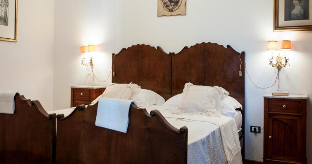 een slaapkamer met een groot houten bed met witte lakens bij Villa Anna Savini Casa Vacanze in Atri