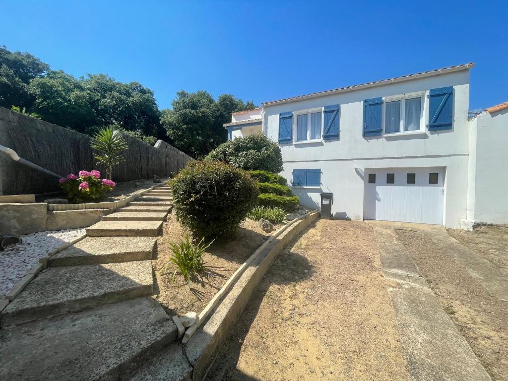 une maison blanche avec une clôture et une allée. dans l'établissement Maison de ville avec jardin, proche plage et commerces, parking privé - La Tranche-sur-Mer - FR-1-22-370, à La Tranche-sur-Mer
