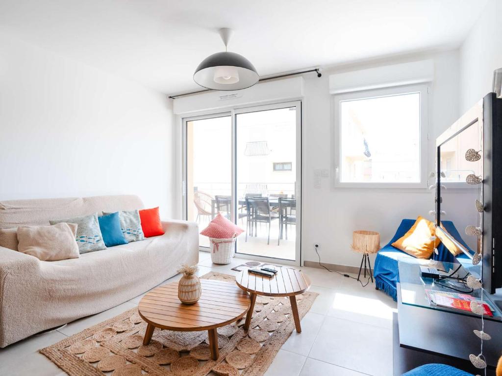 un salon avec un canapé et une table dans l'établissement T3 climatisé neuf, proche plage avec terrasse spacieuse et parking à Narbonne - FR-1-409-272, à Narbonne