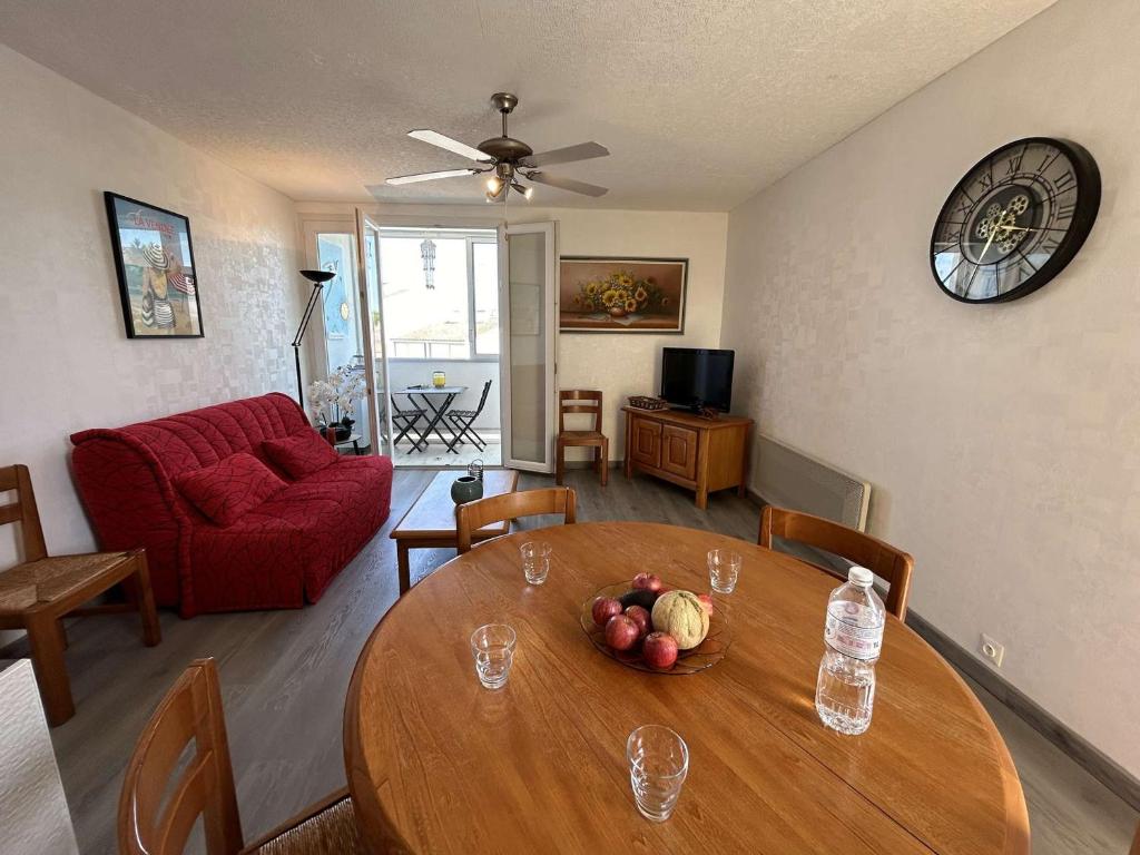un salon avec une table et un canapé rouge dans l'établissement Appartement rénové 300m plage, balcon, parking privé, 4-5 couchages, Saint-Hilaire-de-Riez - FR-1-224C-316, à Saint-Hilaire-de-Riez