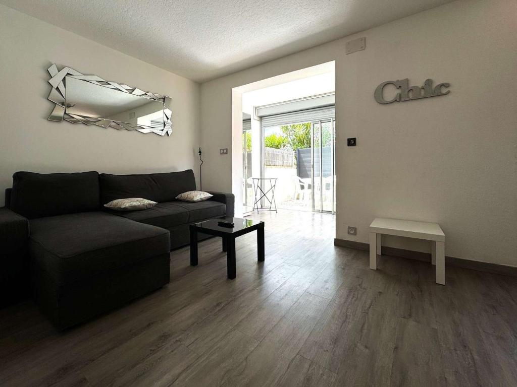 un salon avec un canapé et une table dans l'établissement Charmant T2 Climatisé avec Parking Privé, Jardinet, à 900m de la Plage Roquille - FR-1-607-202, au Cap d'Agde