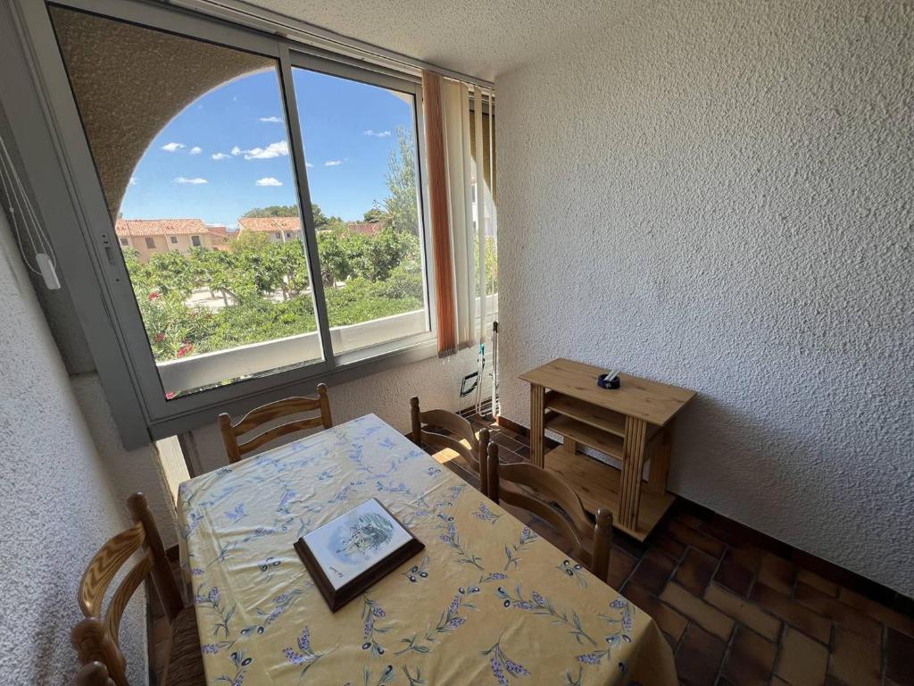 une salle à manger avec une table et une fenêtre dans l'établissement Charmant T2 avec loggia, TV, lave-linge, climatisation portative, proche port et plage à Port Leucate - FR-1-81-621, à Leucate