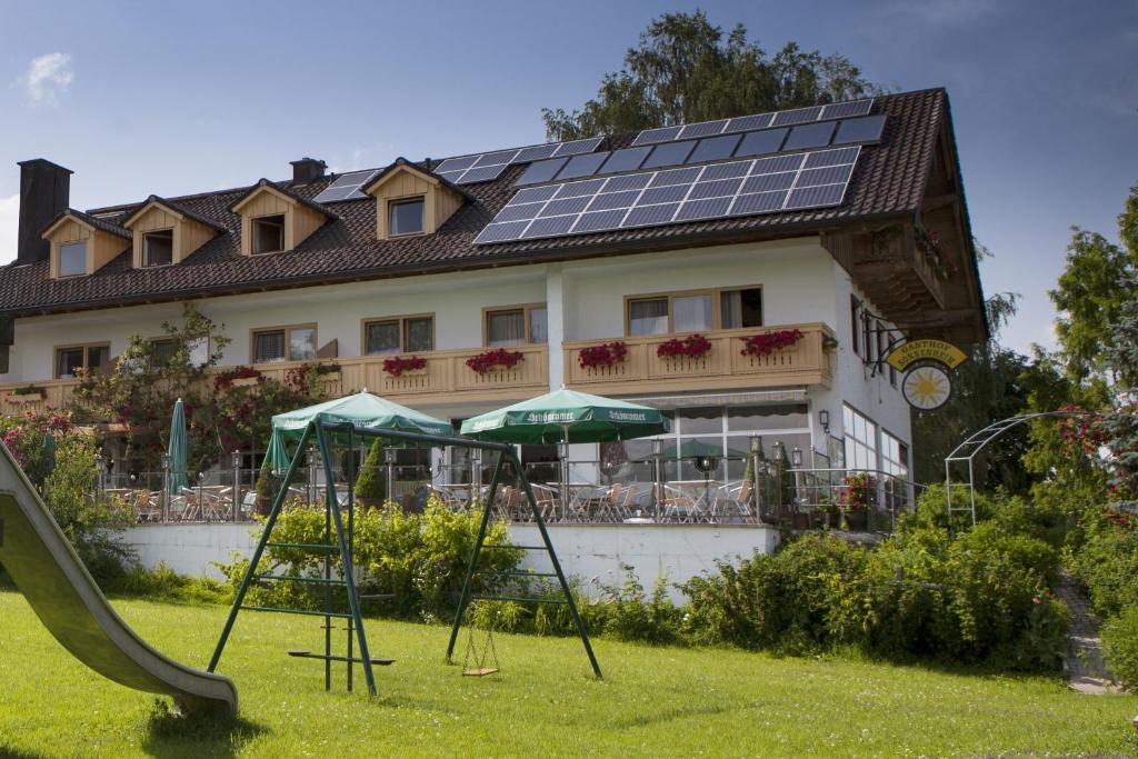 uma casa com painéis solares no telhado com um escorrega em Gasthof Sonnenheim em Saaldorf