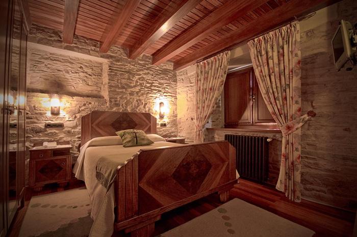 A bed or beds in a room at Alén do Mis - Hotel Rural