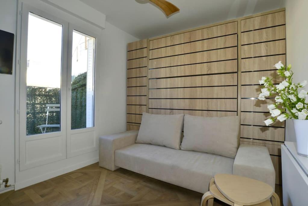 un salon avec un canapé et une fenêtre dans l'établissement My Tiny House Paris, à Paris