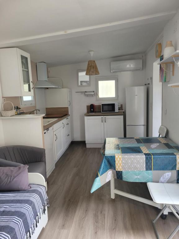 Cet appartement comprend une chambre avec un lit et une cuisine avec des placards blancs. dans l'établissement A 2 pas de la Mer, à Fréjus