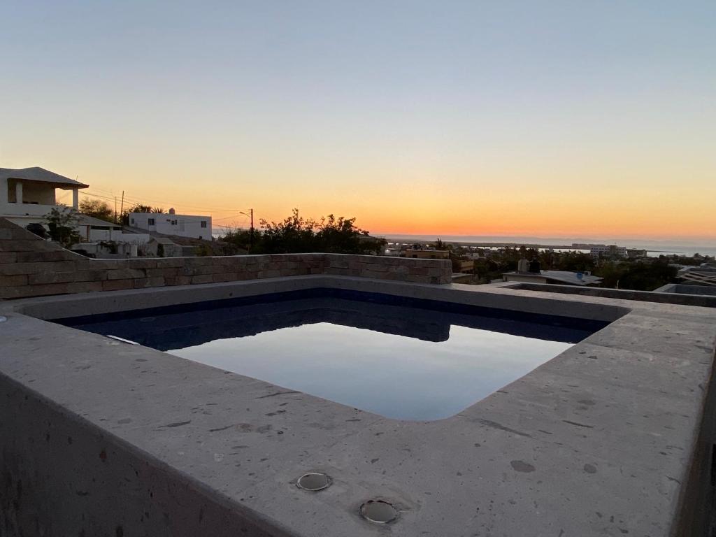 a swimming pool with the sunset in the background at Habitación 1, en Casa Gabriela in La Paz