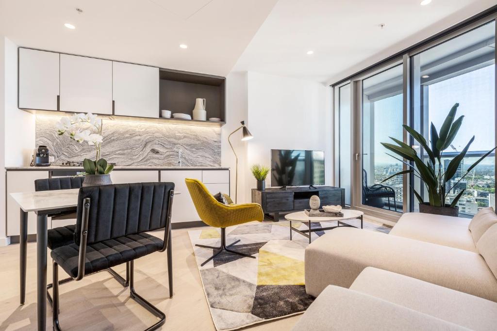 a living room with a couch and a table at West Side Explore Downtown Melb in Chic Condo in Melbourne
