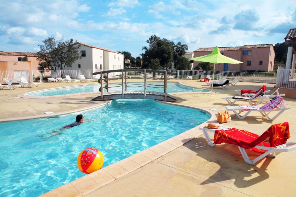 uma pessoa numa piscina com uma bola na água em Résidence Néméa les Portes des Cévennes em Sauve