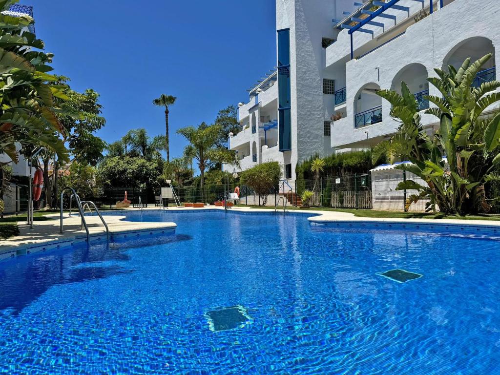 une grande piscine bleue devant un immeuble dans l'établissement Apartamento Playa Ballena - Ole Solutions, à Costa Ballena
