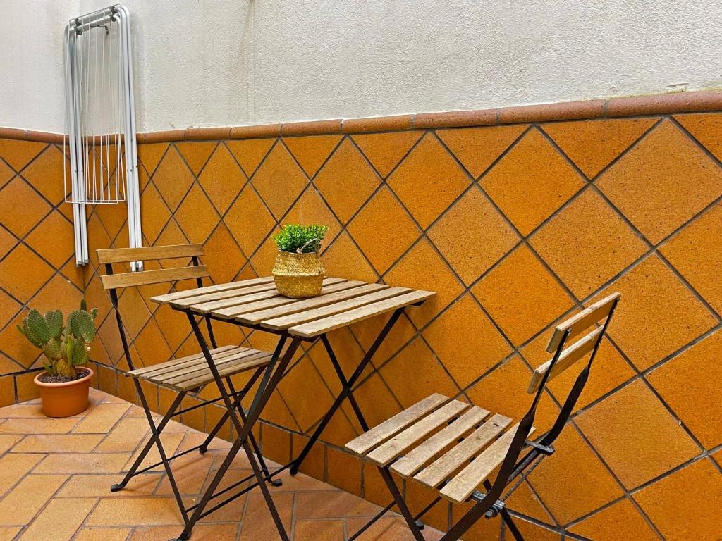 drewniany stół i dwa krzesła oraz stół i roślina w obiekcie Apartamento Armas - Ole Solutions w mieście Jerez de la Frontera