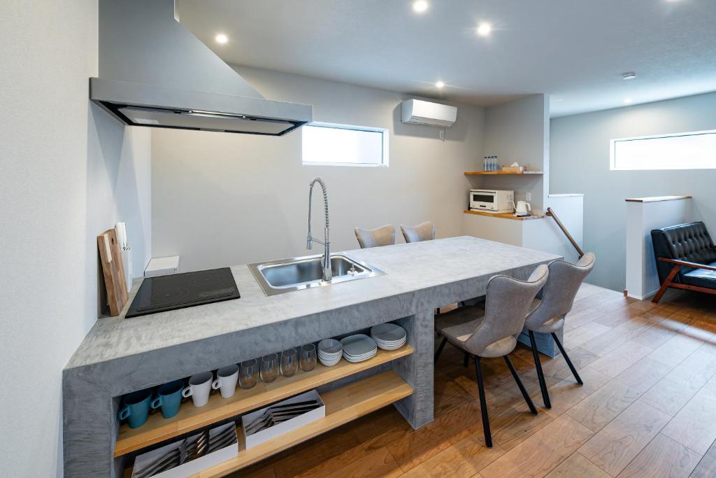 a kitchen with a sink and a counter with chairs at BATEAU rental vacation in Awaji