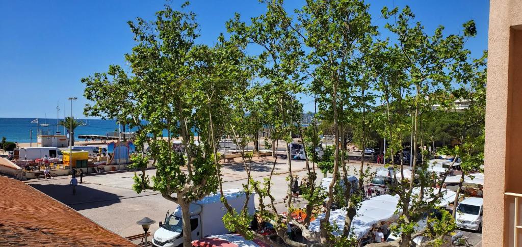 - une vue sur un parking avec des arbres et l'océan dans l'établissement ROSA BAIA Rare 110m2 , 3 chambres, Vue mer, 6 pers, à Fréjus