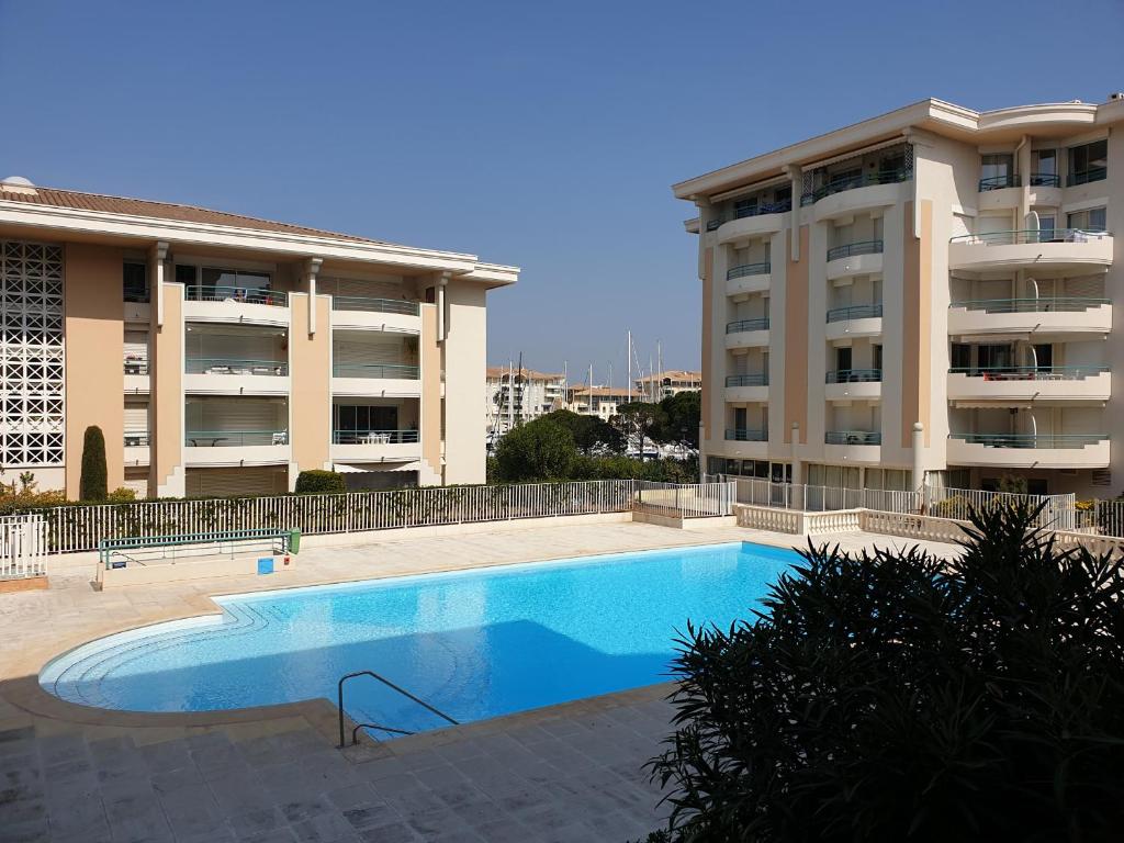 a swimming pool in front of a apartment building at Port Frejus, 100 m des plages, le CESAREE, T2 30m2 in Fréjus