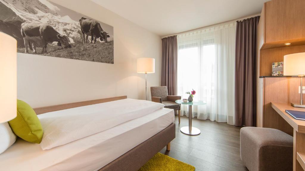Postel nebo postele na pokoji v ubytování AMERON Luzern Hotel Flora