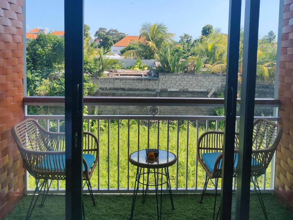 two chairs and a table on a balcony with a view at The Palms Canggu in Canggu