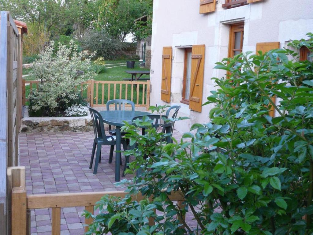 a patio with a table and chairs in a yard at Les boulites in Roches-Prémarie-Andillé