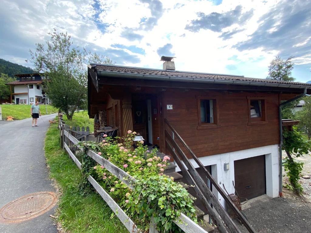 a house with a fence and flowers in front of it at Ferienwohnung HOAMAT in Going am Wilden Kaiser