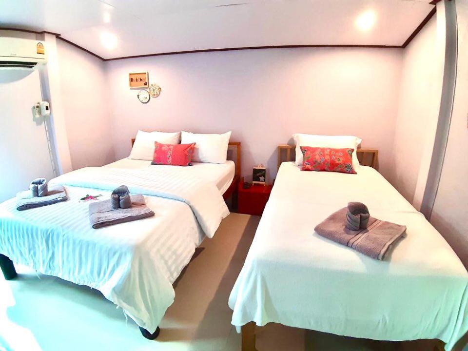 Zimmer mit 2 Betten mit Hüten und Handtüchern in der Unterkunft รรินธารา รีสอร์ท in Ban Bang Khan