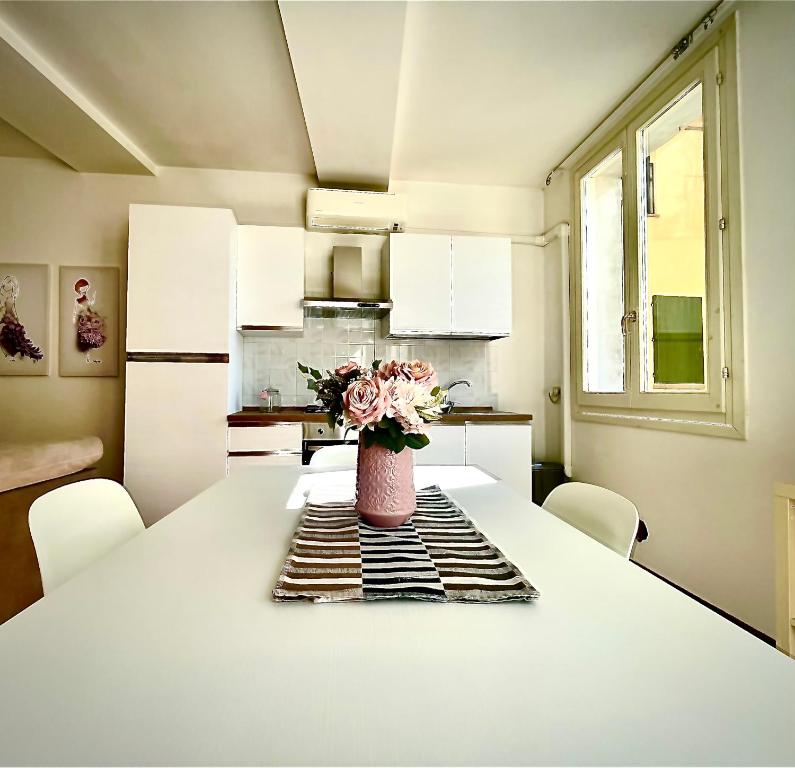 a kitchen with a table with a vase of flowers on it at Canalchiaro55 in Modena