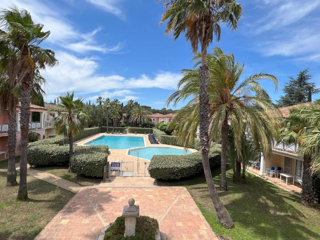 - une vue sur la piscine bordée de palmiers dans l'établissement Grimaud La Palmeraie, à Grimaud