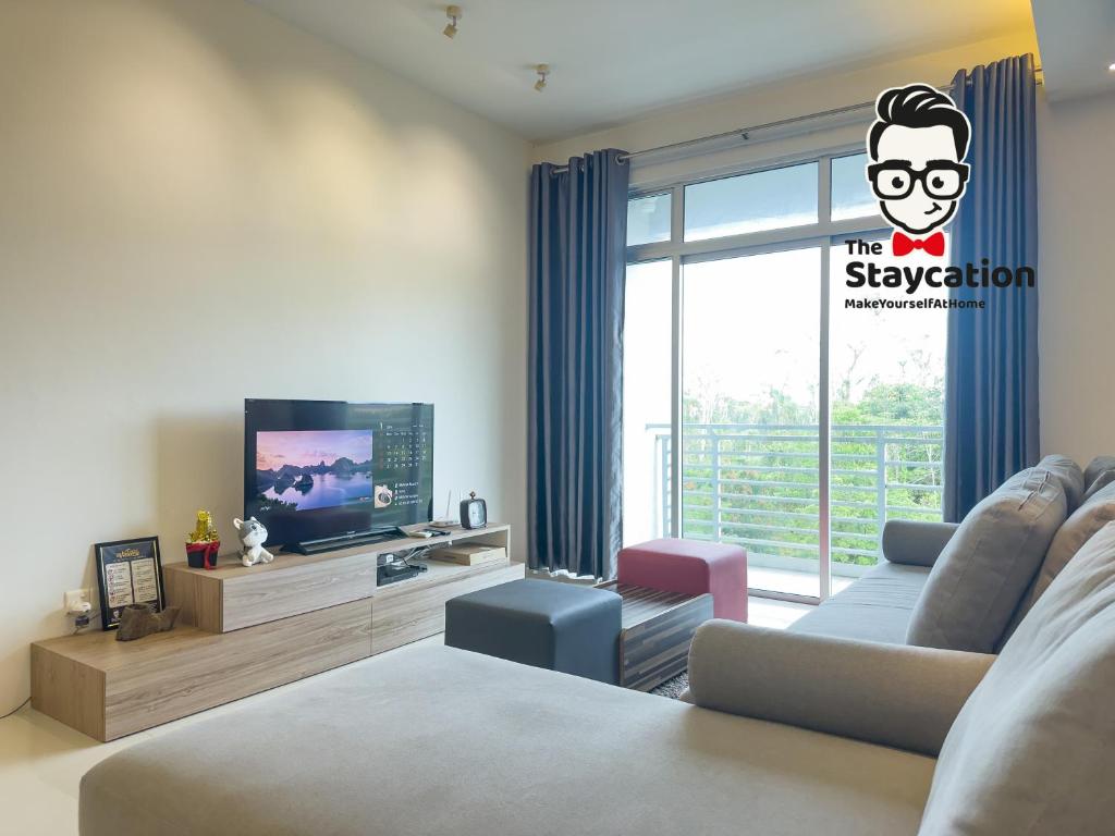 Una sala de estar con un sofá y un televisor. en Staycation Homestay 54 Skyvilla Condo near MJC, en Kuching