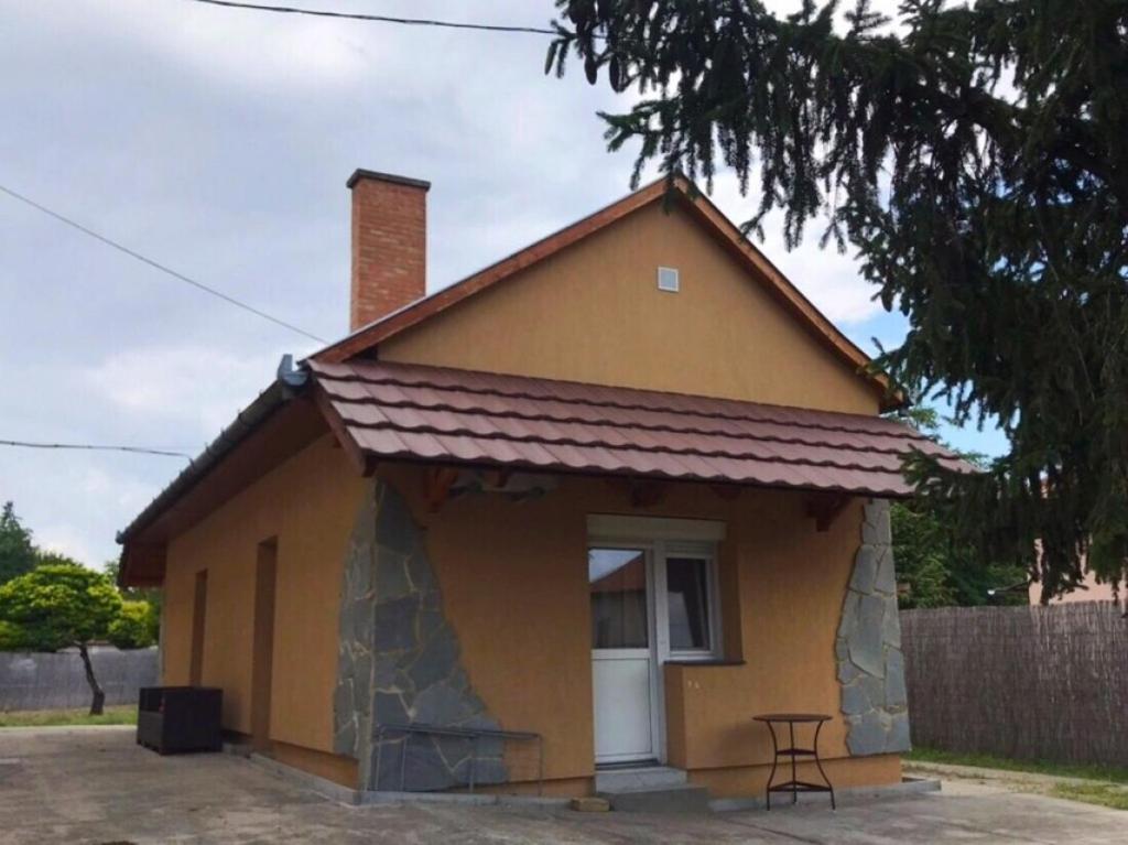 mały żółty dom z oknem w obiekcie Jázmin Apartmanok w mieście Mórahalom