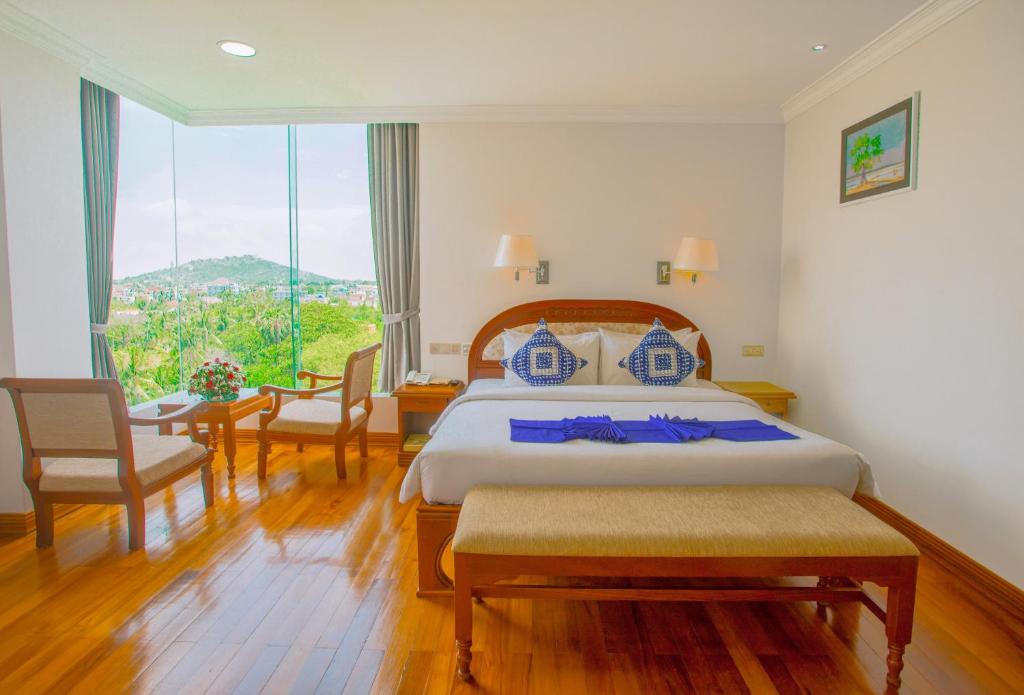 a hotel room with a bed and a large window at Mandalay Lodge Hotel in Mandalay