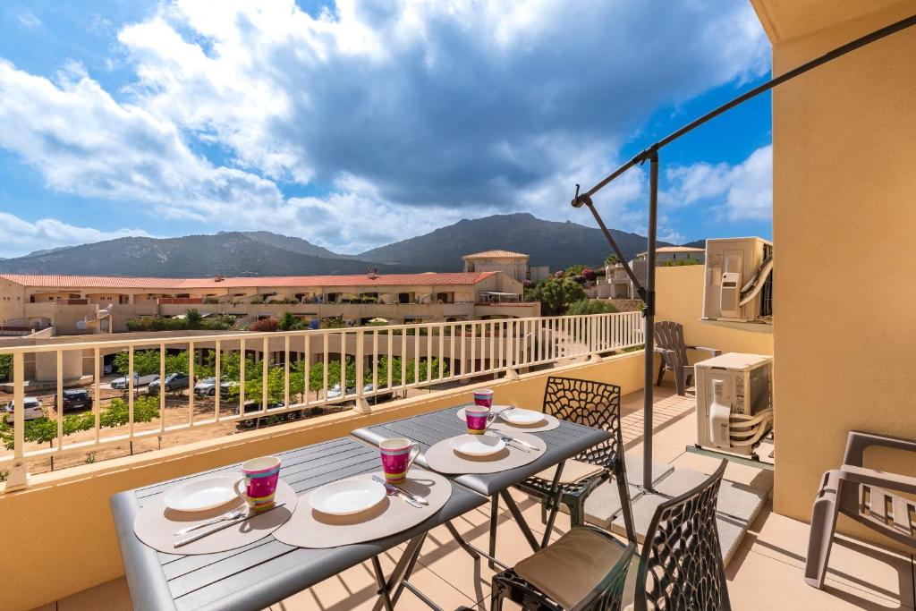 une table et des chaises sur un balcon avec vue dans l'établissement Amicu - Appt climatisé vue mer, à Lumio