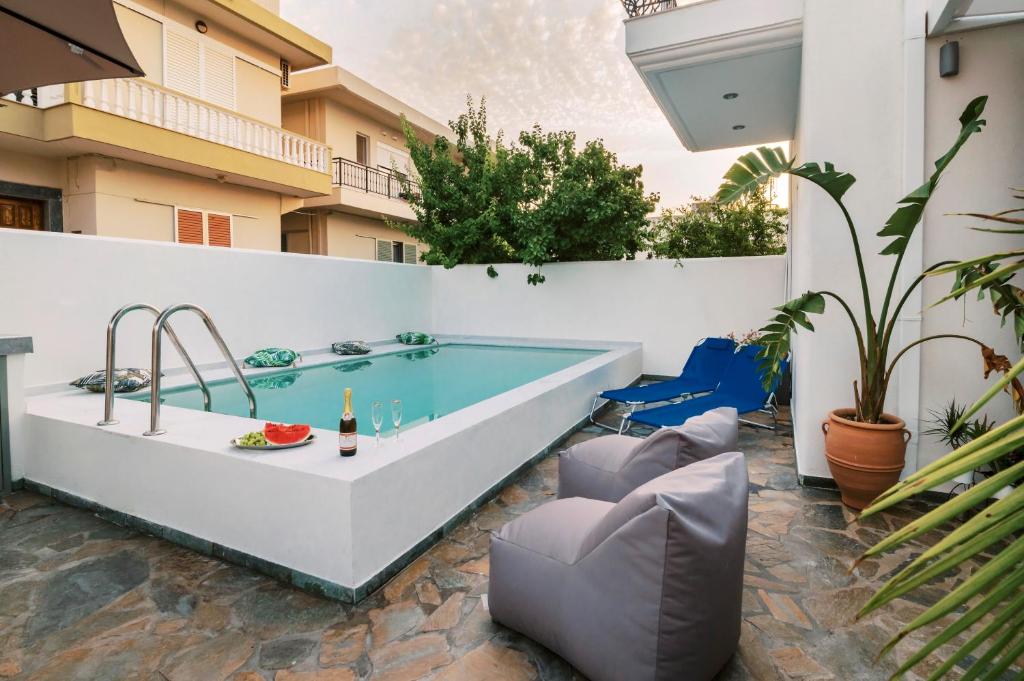 a swimming pool in the middle of a patio with a table and chairs at Koskinou Escape Villa Private Pool in Koskinou