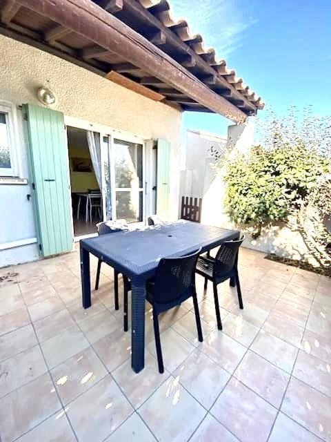a blue table and chairs on a patio at T2 cabine avec piscine collective, parking, climatisation pour 4 personnes in Saintes-Maries-de-la-Mer