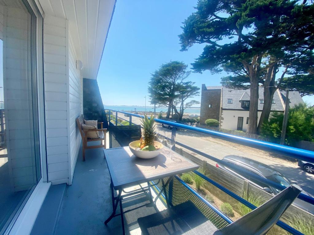 d'un balcon avec une table et une vue sur la rue. dans l'établissement CARAVELLE - Vue mer, St Colomban - T16, à Carnac