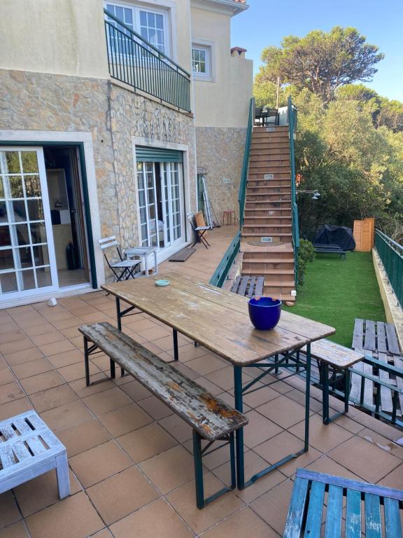 a wooden table and benches on a patio at Amazigh Guincho Hostel & Suítes in Cascais