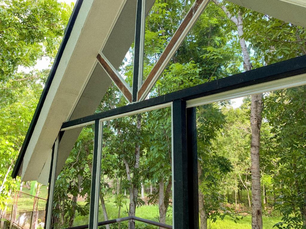 una finestra in una casa che guarda gli alberi di Balay Hilway - Cozy Rustic Cabin a Sara