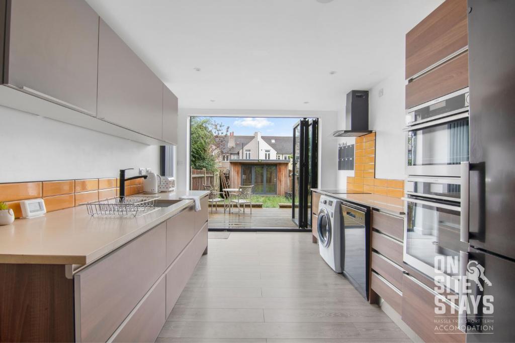a kitchen with a sink and a dishwasher at OnSiteStays Dartford 4BR House with Garden, bathroom and ensuite in Dartford
