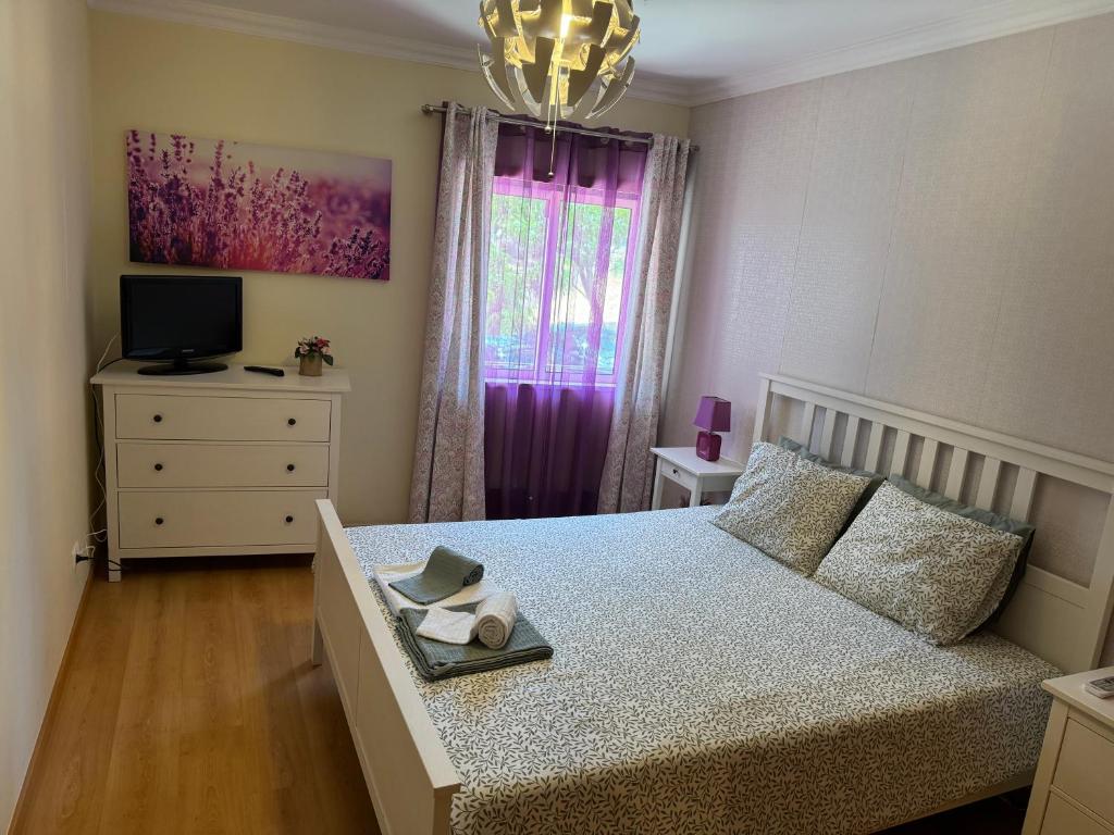 a bedroom with a bed with a dresser and a window at Montenegro Dreams in Faro