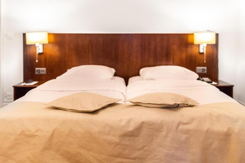 a large bed with two pillows on top of it at J5 Hotels Helvetie & La Brasserie in Montreux