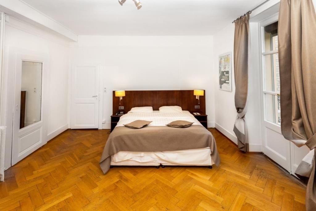 a bedroom with a large bed in a white room at J5 Hotels Helvetie & La Brasserie in Montreux