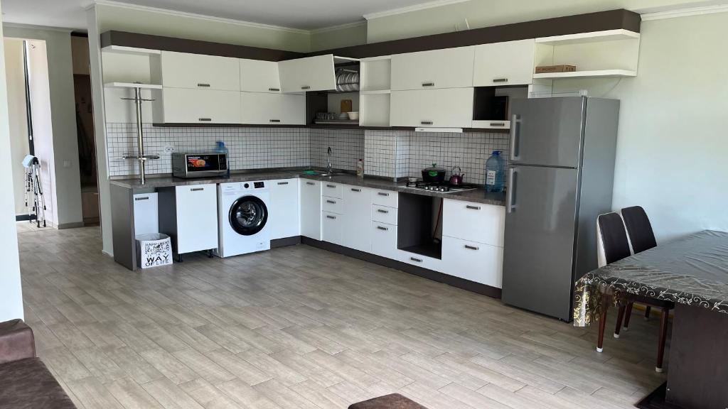 Una cocina con gabinetes blancos y un refrigerador. en Magnetiti, en Ureki