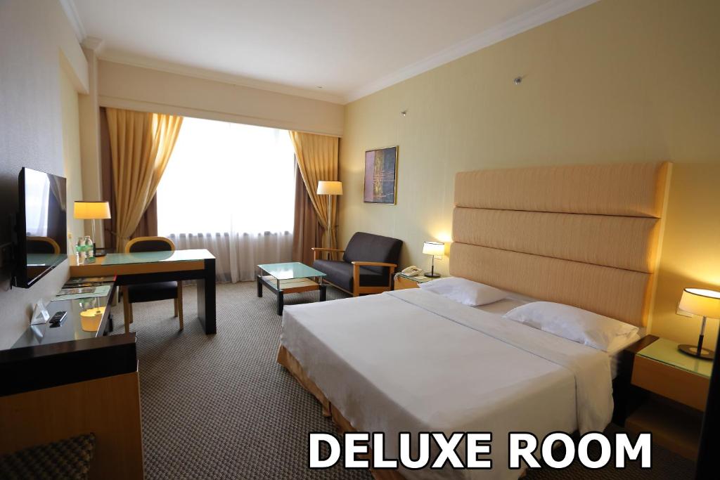 Postel nebo postele na pokoji v ubytování Dynasty Hotel Miri