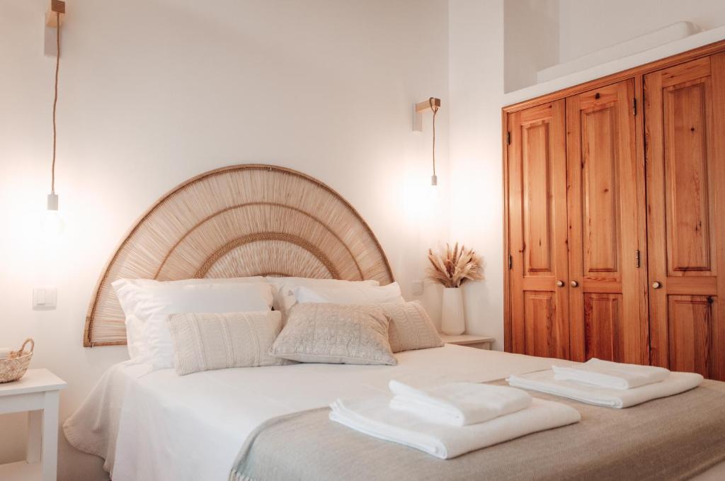 Un dormitorio con una gran cama blanca con dos toallas encima. en Slow House Green Villa, en São Brás de Alportel