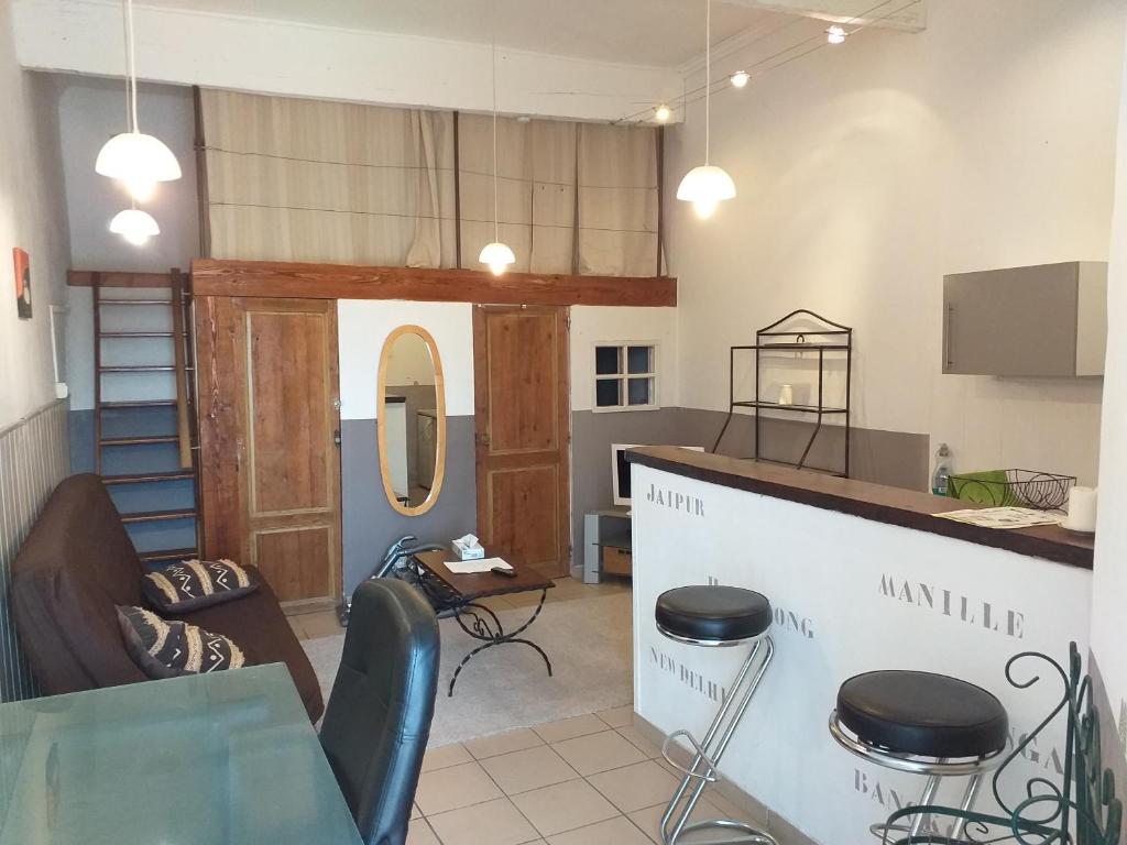 Cette chambre comprend une table, des chaises et un comptoir. dans l'établissement le drop point des rencontres photos, à Arles